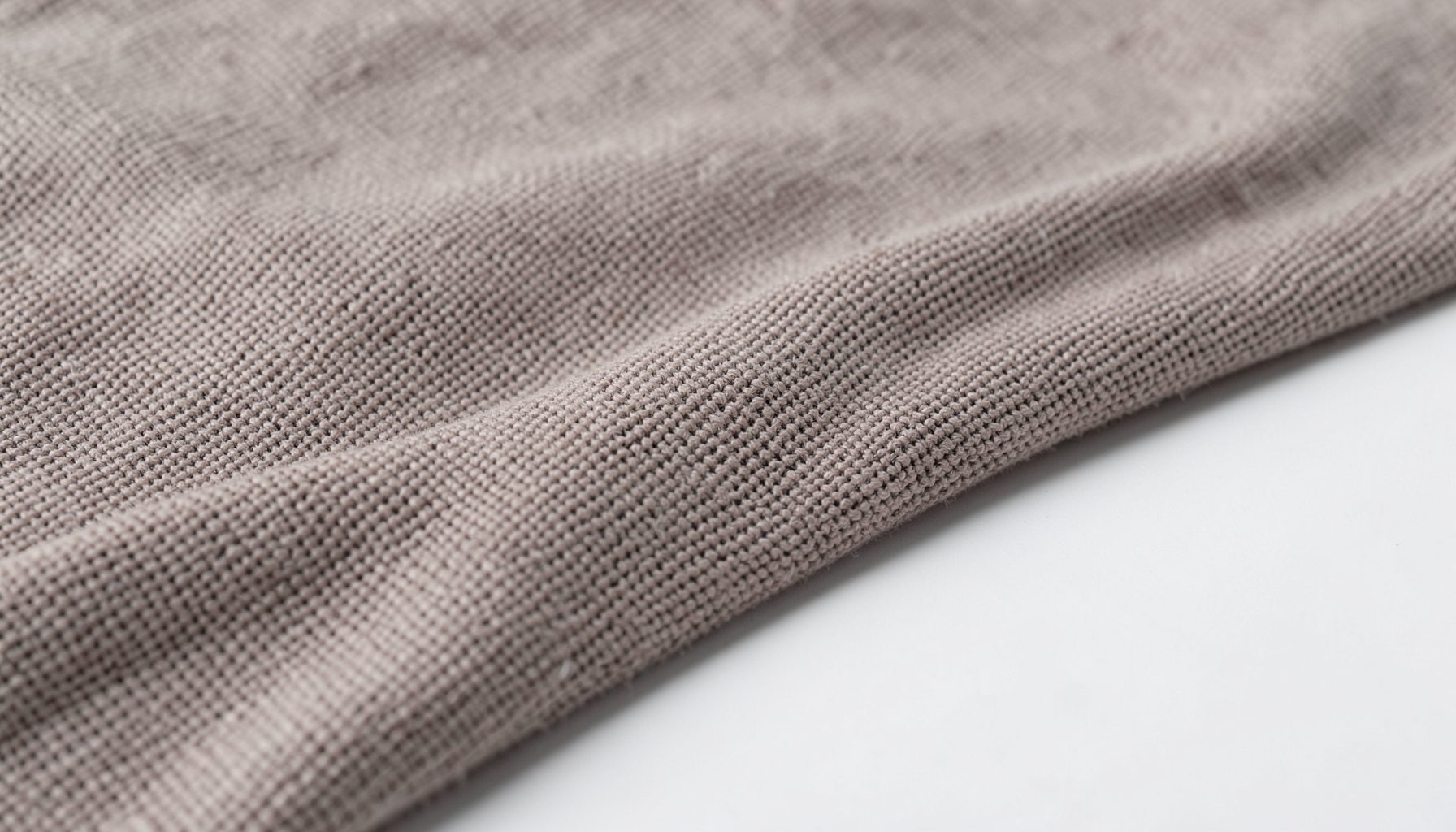 Tecido em malha de algodão em tom taupe com textura entrelaçada, superfície suave e neutra